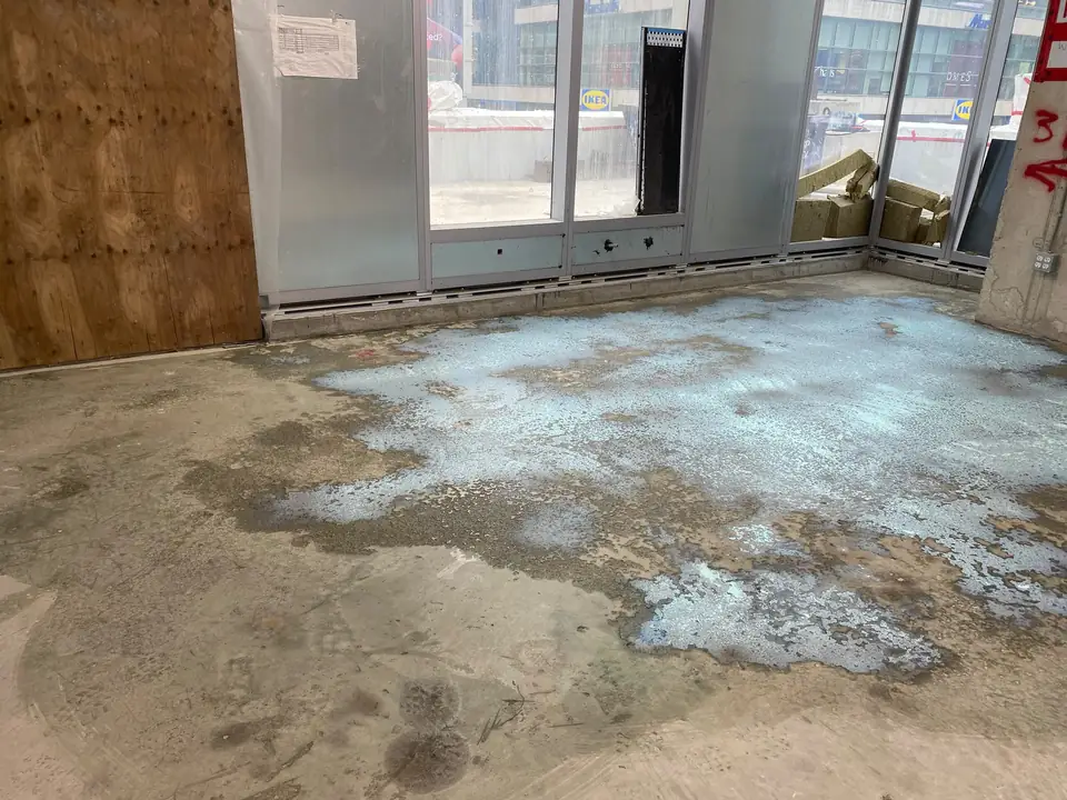 Retail unit concrete floor covered in old adhesive residue before floor preparation