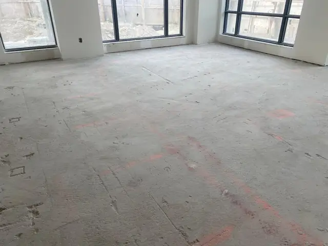 High-rise condo concrete floor with orange layout marks before floor leveling