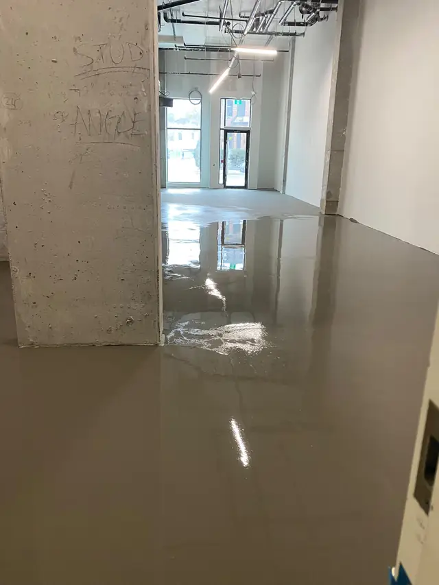 Self-leveling concrete poured in a commercial retail space around a concrete column