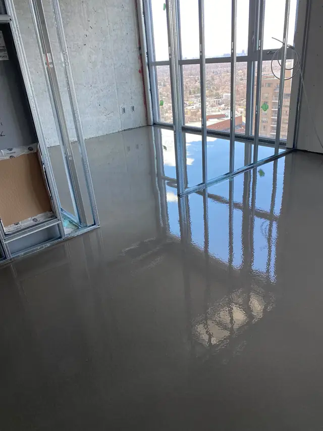 Finished self-leveling concrete floor in a high-rise condo, flat and ready for flooring