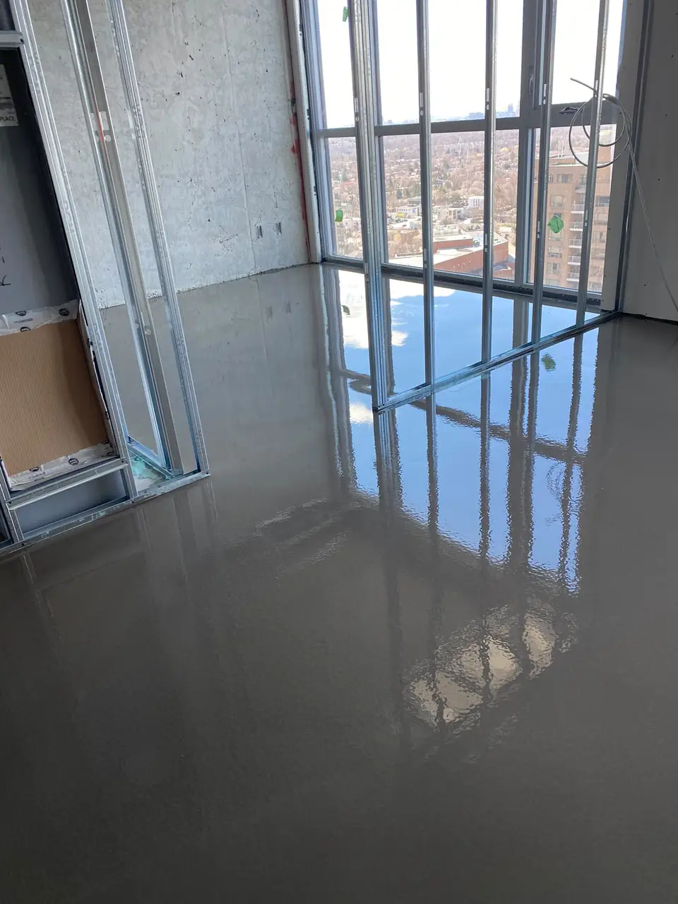 Finished self-leveling concrete floor in a high-rise condo, flat and ready for flooring