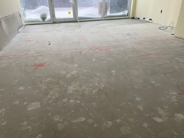 Uneven concrete floor with old residue before grinding and self-leveling